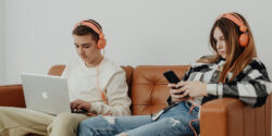 two teenagers using job apps on a phone and laptop