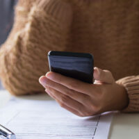 Close view of a woman taking a survey on her smartphone.