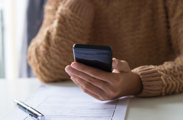 Close view of a woman taking a survey on her smartphone.