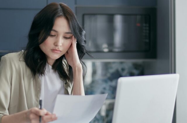 Independent worker frowning at a task she's partially outsourced to AI.