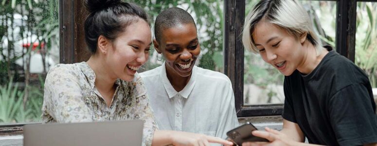 Group of people sitting and taking online surveys on a phone.