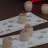 Bingo cards on a table with wooden stamps.