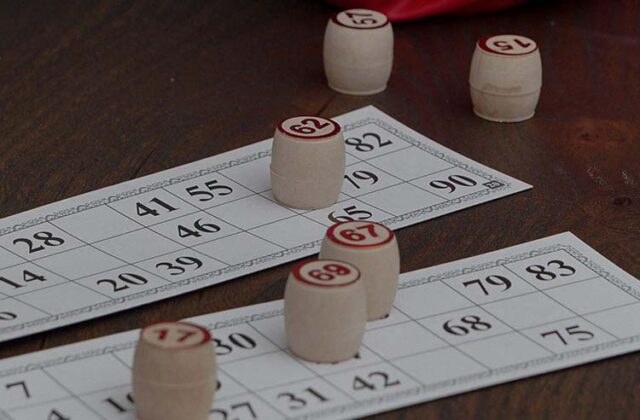 Bingo cards on a table with wooden stamps.