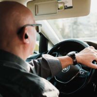 Uber driver sitting at the wheel of his car.