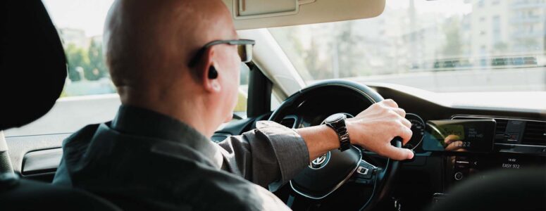 Uber driver sitting at the wheel of his car.