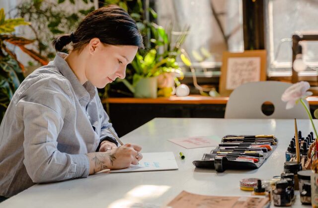 Creative side hustler sitting at a desk working on a project.
