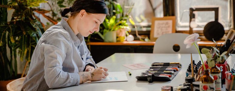 Creative side hustler sitting at a desk working on a project.