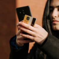 Ibotta user holding a phone and a credit card just after making a purchase.