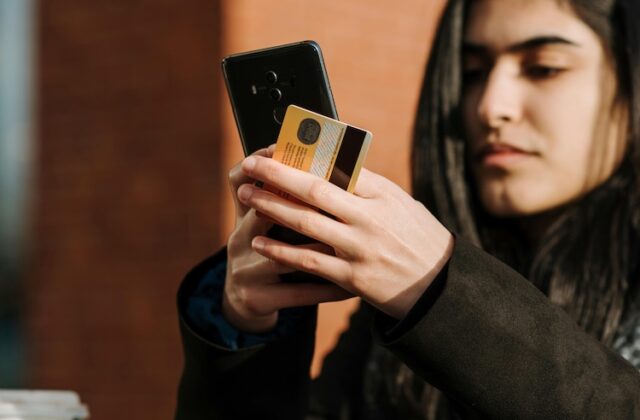 Ibotta user holding a phone and a credit card just after making a purchase.