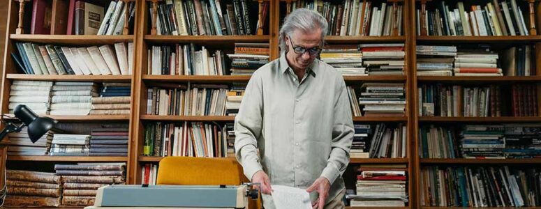 Older librarian handling a book for his side hustle as a book flipper.