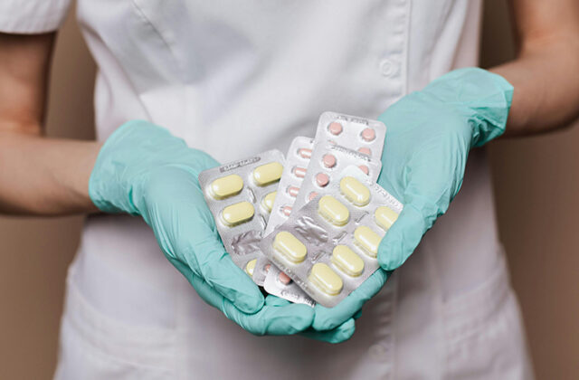 Pharmacist holding several containers of pills for their side hustle as a pharmaceutical sales rep.