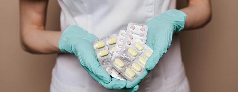 Pharmacist holding several containers of pills for their side hustle as a pharmaceutical sales rep.