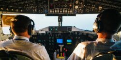 Pilot sitting in a cockpit chatting about side hustles with his copilot.