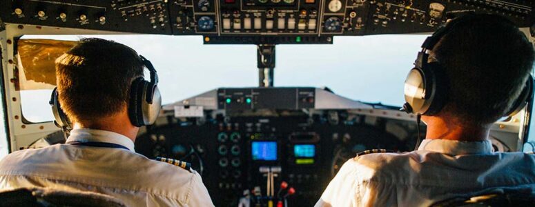 Pilot sitting in a cockpit chatting about side hustles with his copilot.