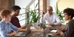 Project manager sitting at his laptop consulting with a client for his side hustle.