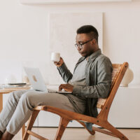 Person sitting in a chair and browsing work-on-demand job opportunities on a laptop