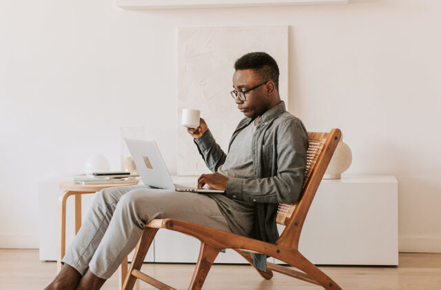 Person sitting in a chair and browsing work-on-demand job opportunities on a laptop