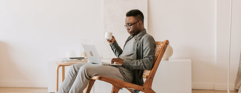 Person sitting in a chair and browsing work-on-demand job opportunities on a laptop