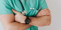Close view of a physician dressed in blue scrubs.