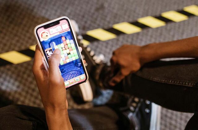 Close view of someone holding a phone with a pay-for-cash game on the screen.