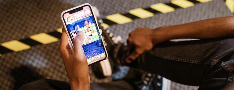 Close view of someone holding a phone with a pay-for-cash game on the screen.