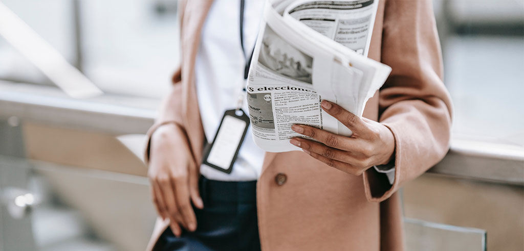 A woman is reading a newspaper