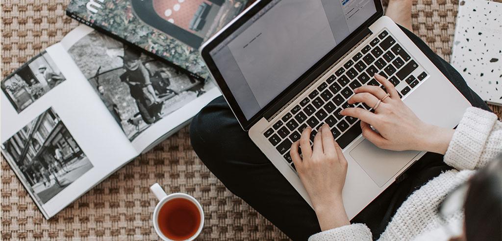 a freelancer is typing something on her laptop