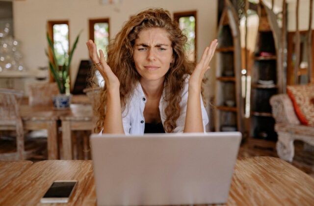 A frustrated job seeker staring in confusion at a fake remote job listing on computer.