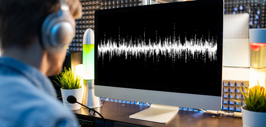 Freelance transcriptionist looking at a visualization of an audio file on a computer