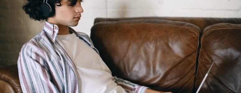 Transcriber on his couch completing a Babbletype assignment on his laptop.
