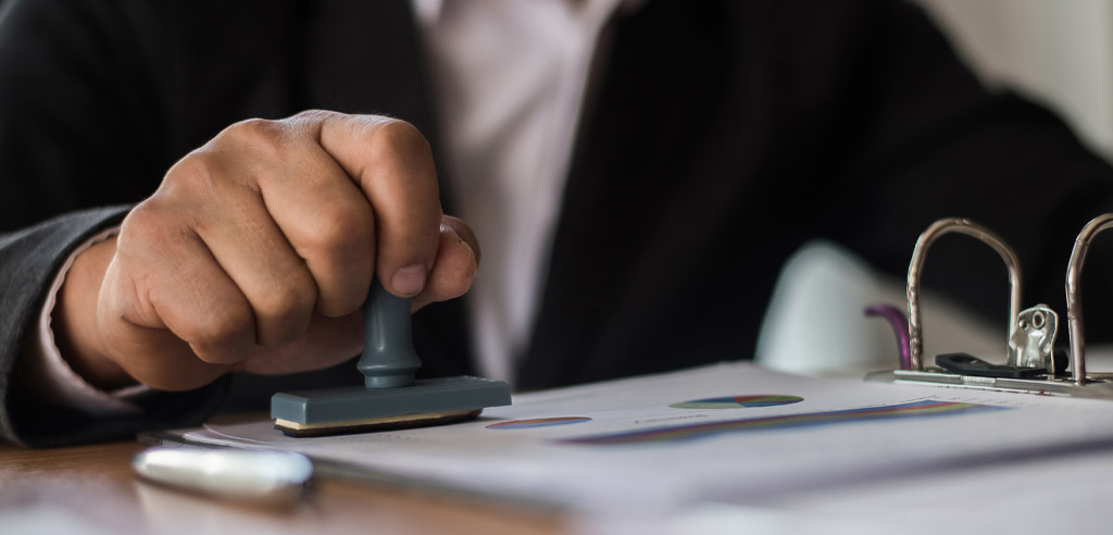 Close view of a man stamping a piece of paper