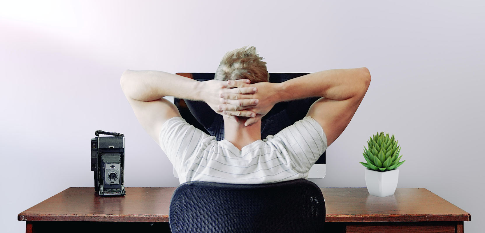 Man leaning back in his computer chair and contemplating starting a freelance proofreading side hustle
