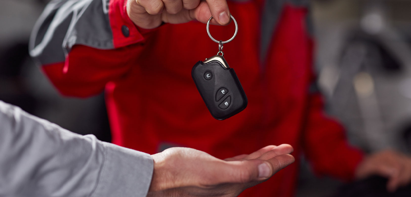 Man passing a car key to a renter