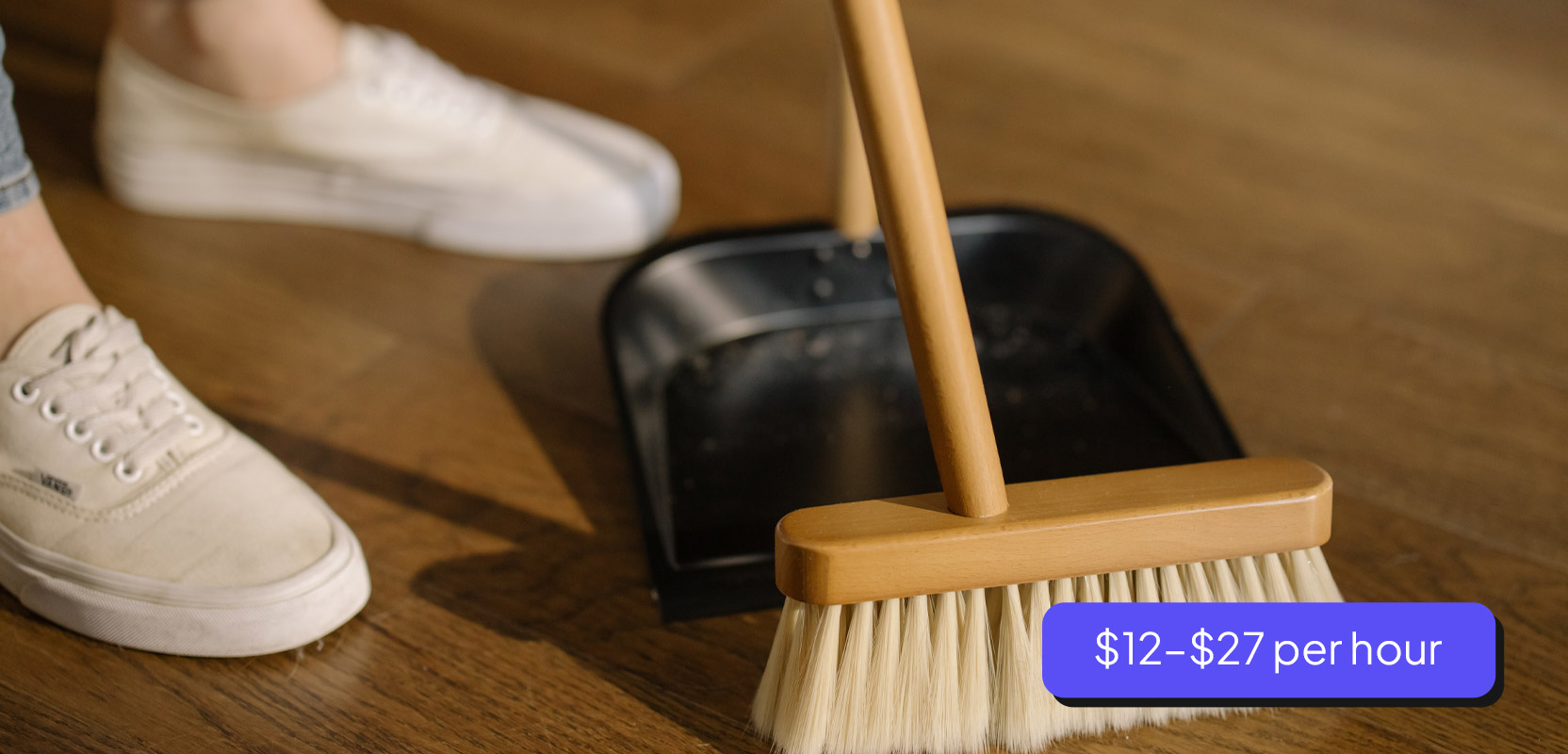Cleaner sweeping a floor with a broom as part of their side hustle