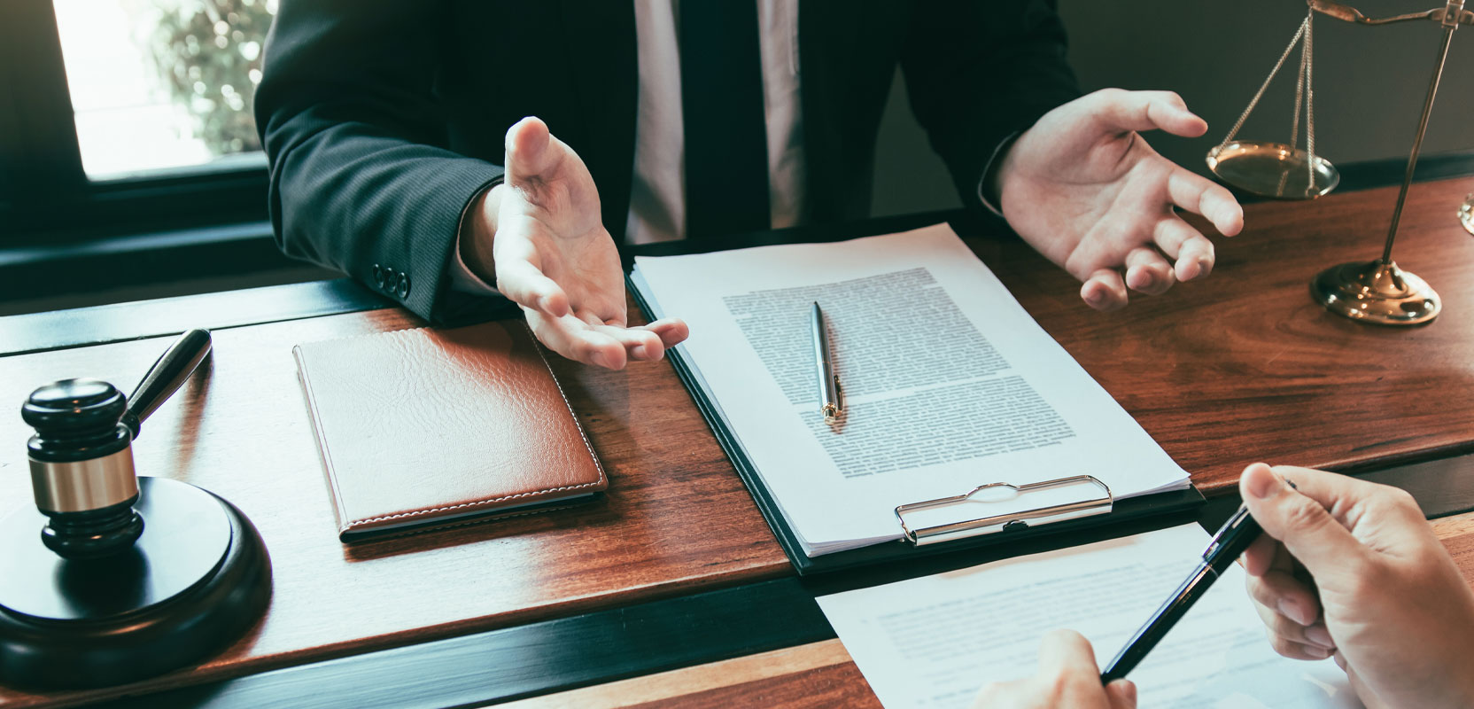 Legal consultant sitting at a desk giving advice to a client as part of a side hustle