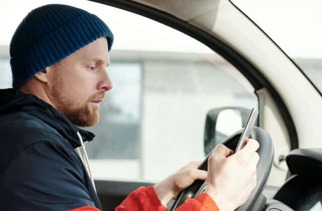 Delivery driver on his phone in his car.