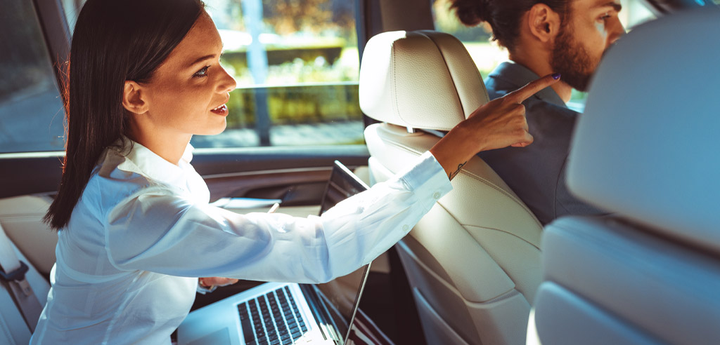 Woman sitting in the back seat of an Uber giving directions to the driver