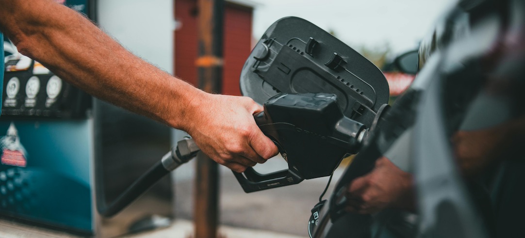 Closeup of a person filling up their car with gas.