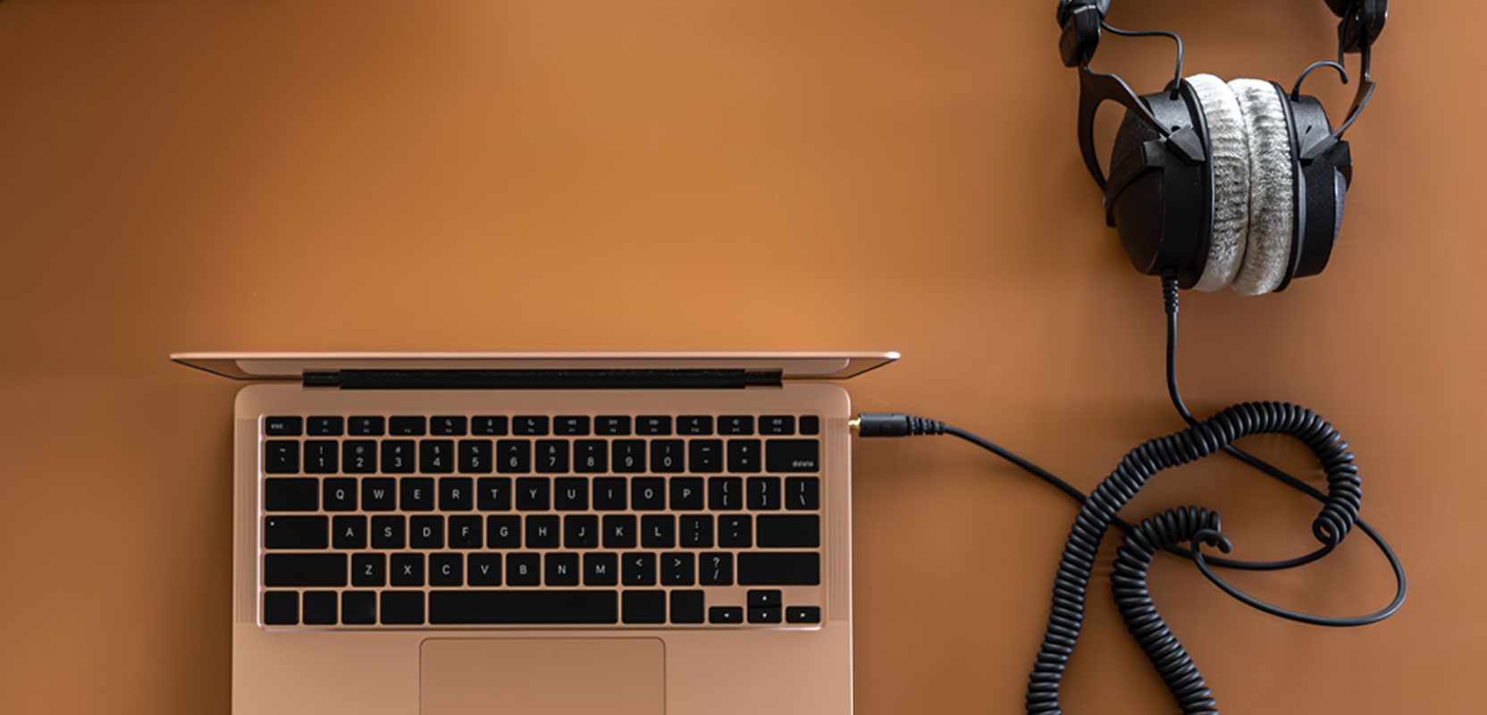 Laptop and headphones on a desk, top view