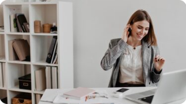 woman on phone at desk working remotely for her part time job
