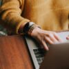 Close view of a freelance grant writer as they work on their laptop.