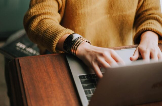 Close view of a freelance grant writer as they work on their laptop.