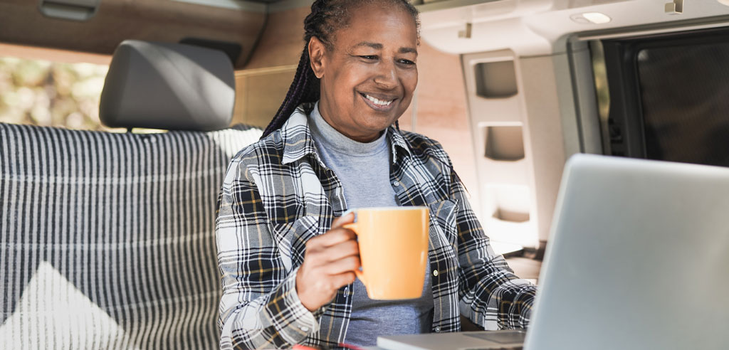 Older woman sitting at a laptop working on a freelance writing side hustle