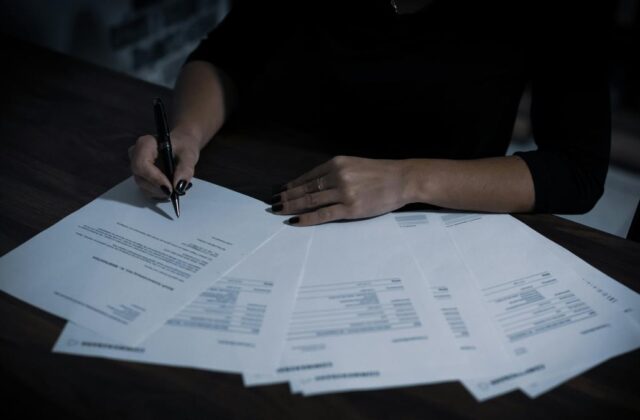 Close view of a freelance writer working on their taxes.