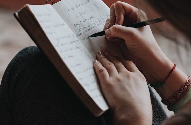 Freelancer writing by hand in their notebook.