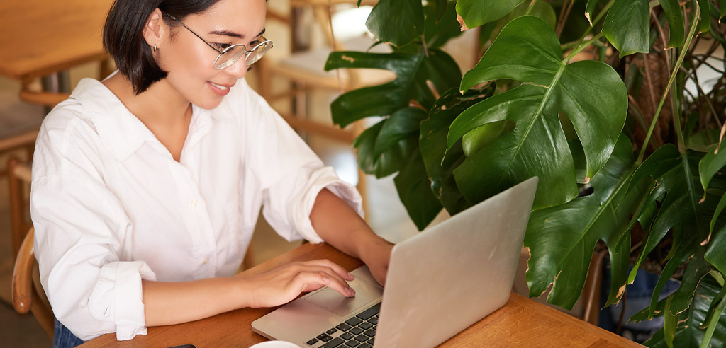 Woman sitting at a laptop working on her freelance writing side hustle