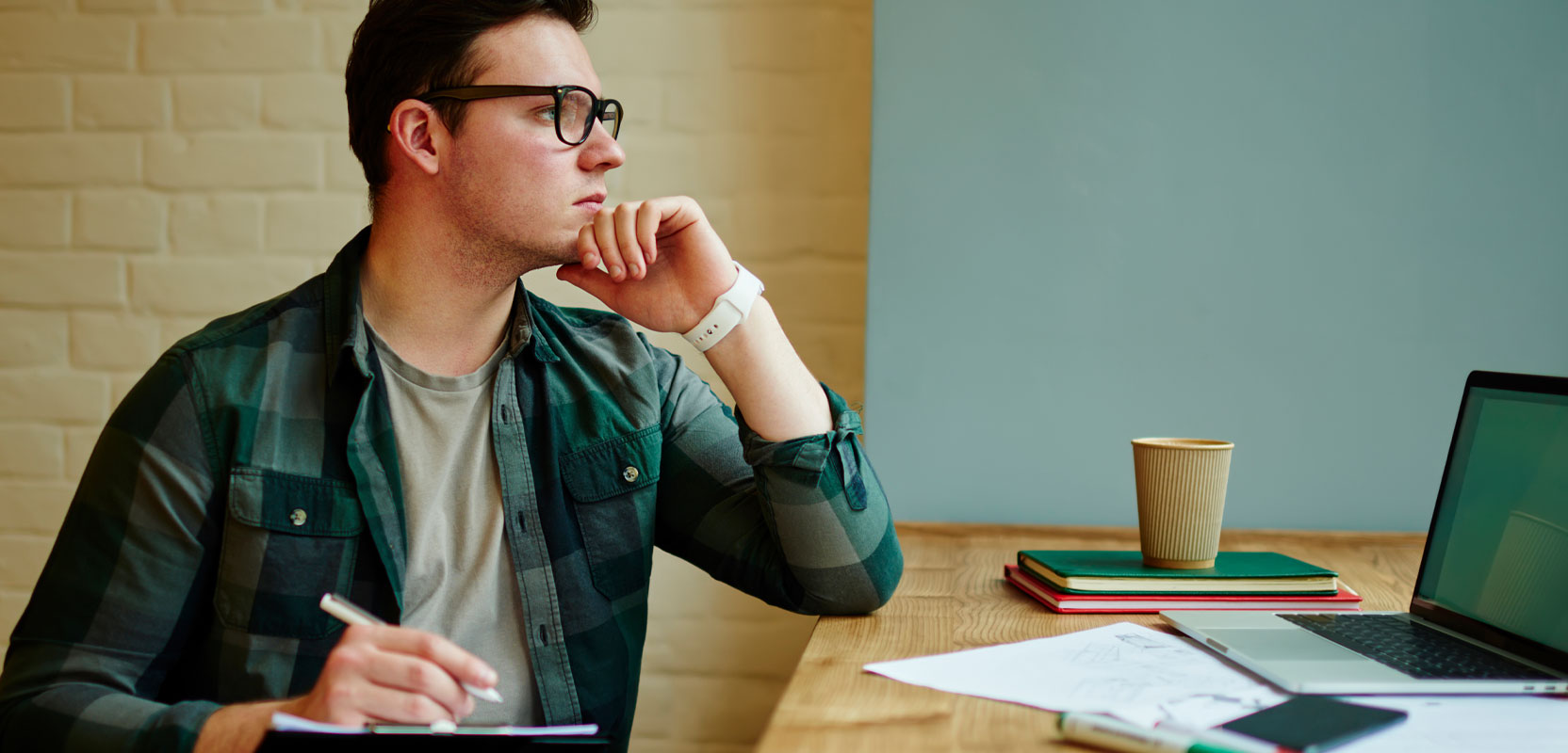 Freelance writer sitting at his laptop and thinking about how to get his first job