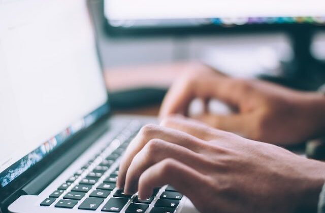 Close view of a freelance CPRW creating a resume for a client on a laptop.