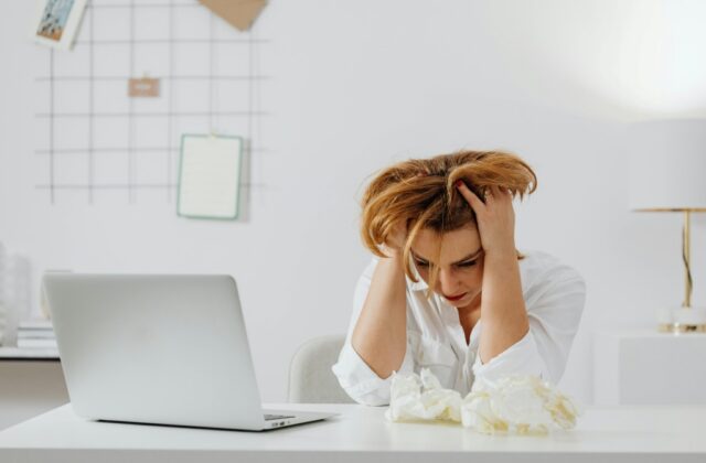 Job seeker pulling her hair in frustration after being rejected due to her employment status.