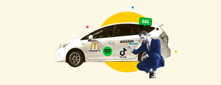 Man sitting in front of his car with lots of advertisements that he was paid to put on it